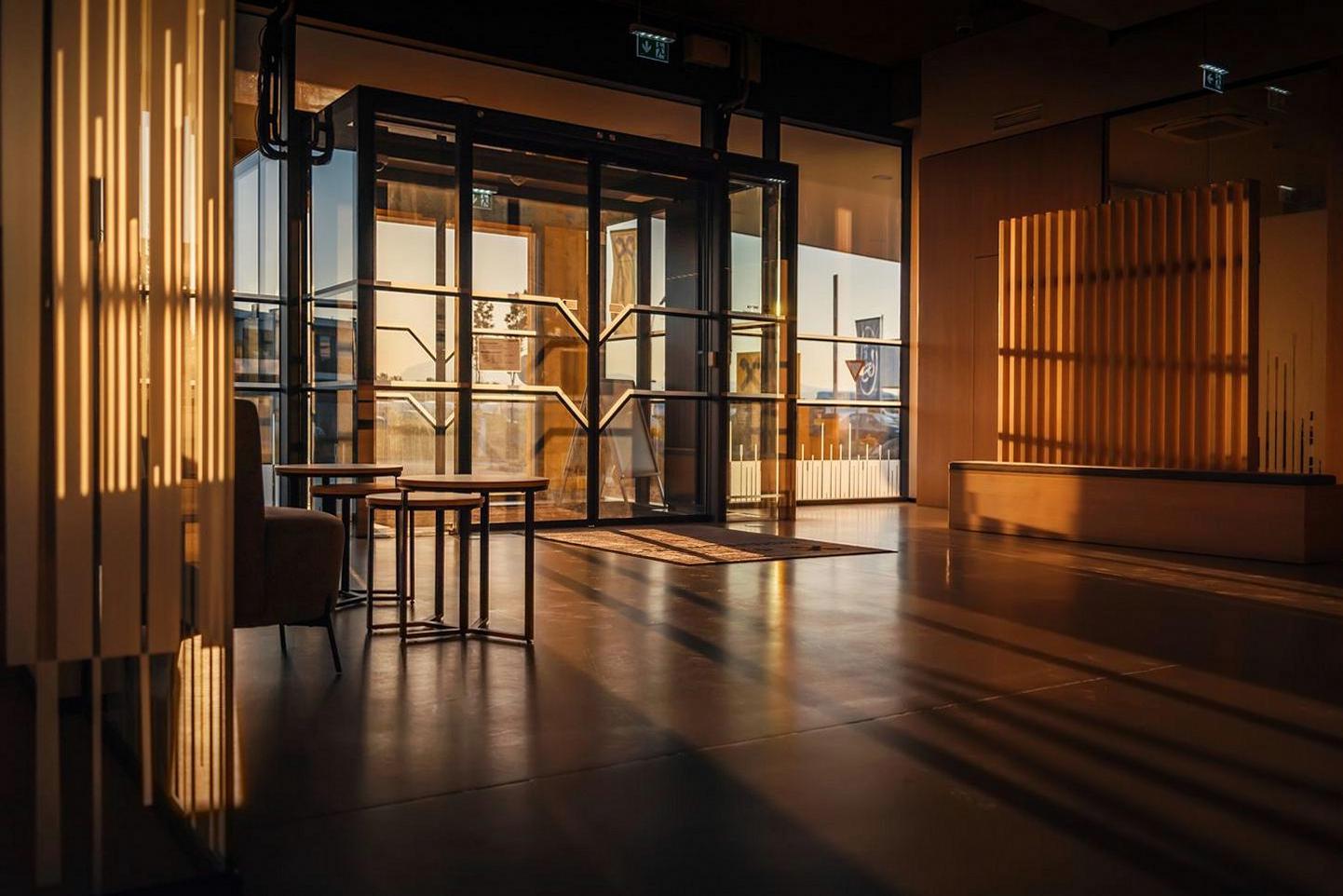Sun-drenched Brightvibes Hotel lobby with warm wood accents